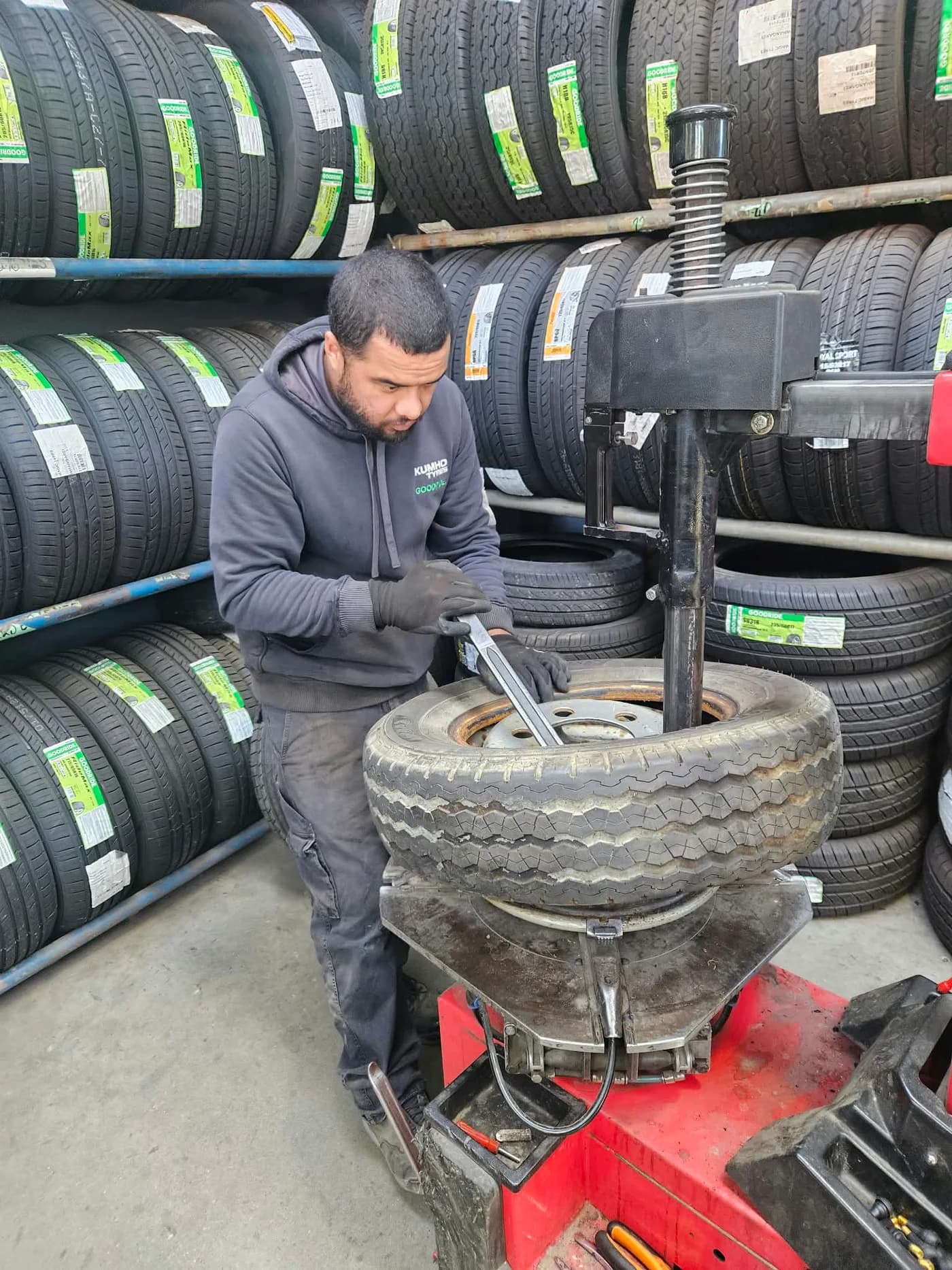 Technician removing a tyre from its rim in the workshop